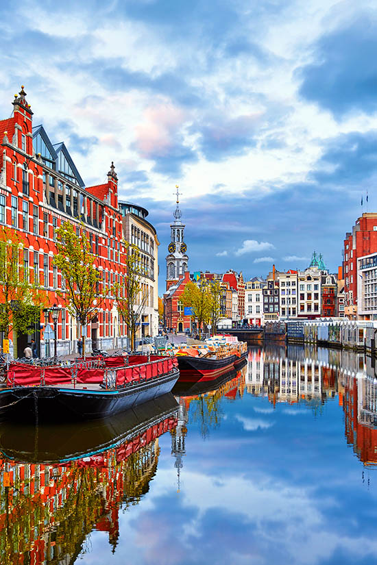 Kanal in Amsterdam, historische Gebäude und Schiffe, Städtereise nach Amsterdam